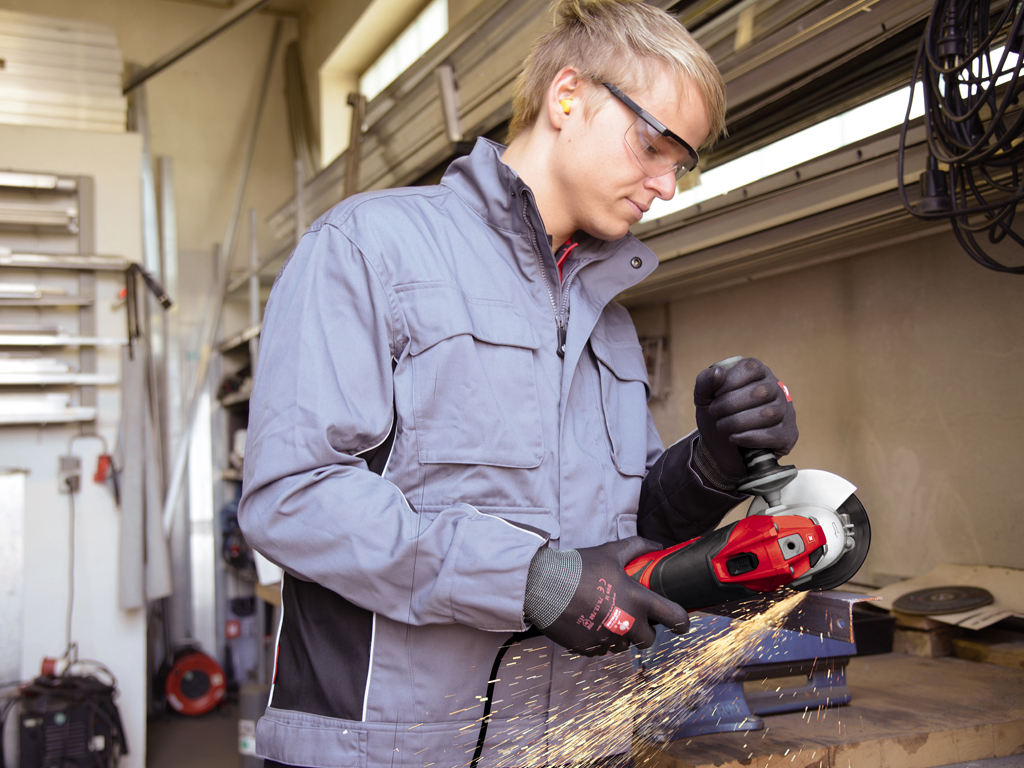 man cuts a piece of iron an sparks fly