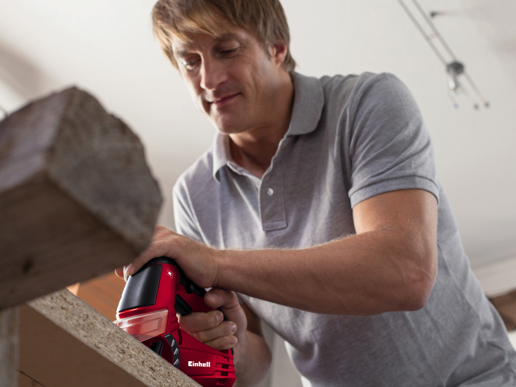 a man concentrated cuts a wood with a jigsaw