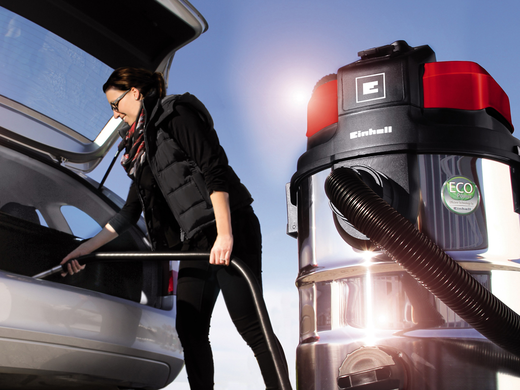 woman sucks out the trunk with a vacuum cleaner