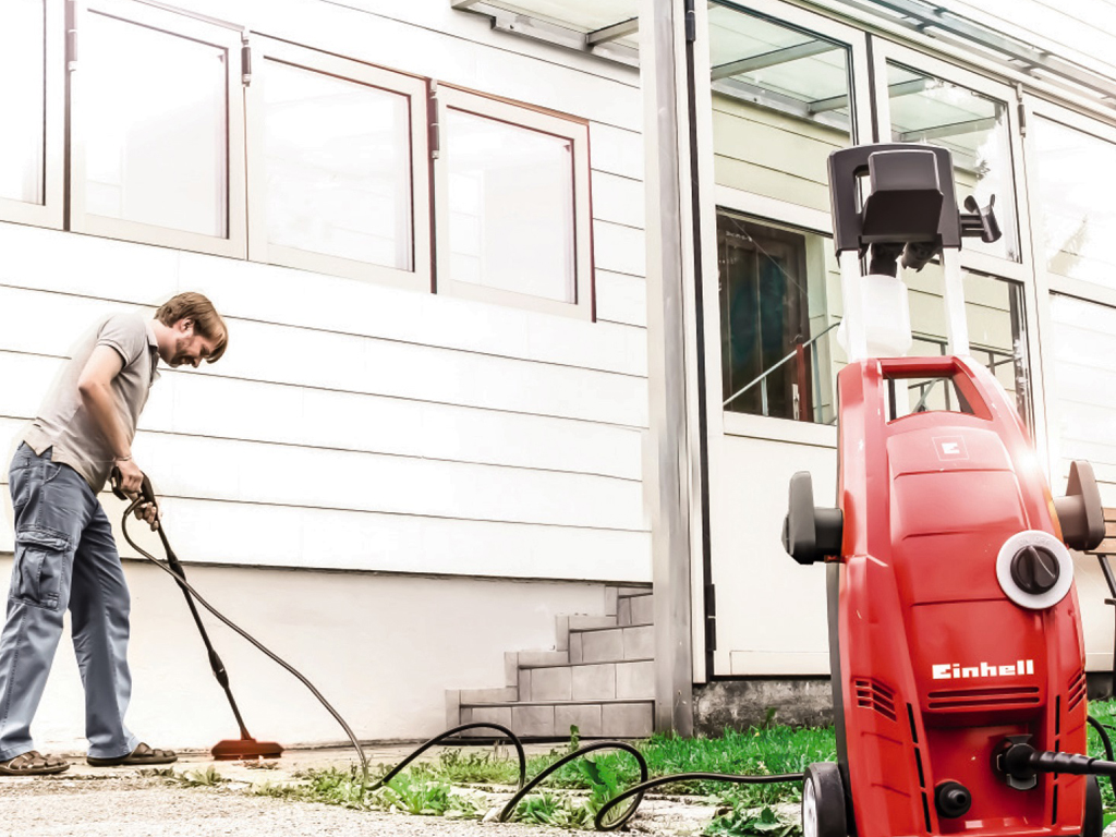 man cleans pavement in front of the entrance