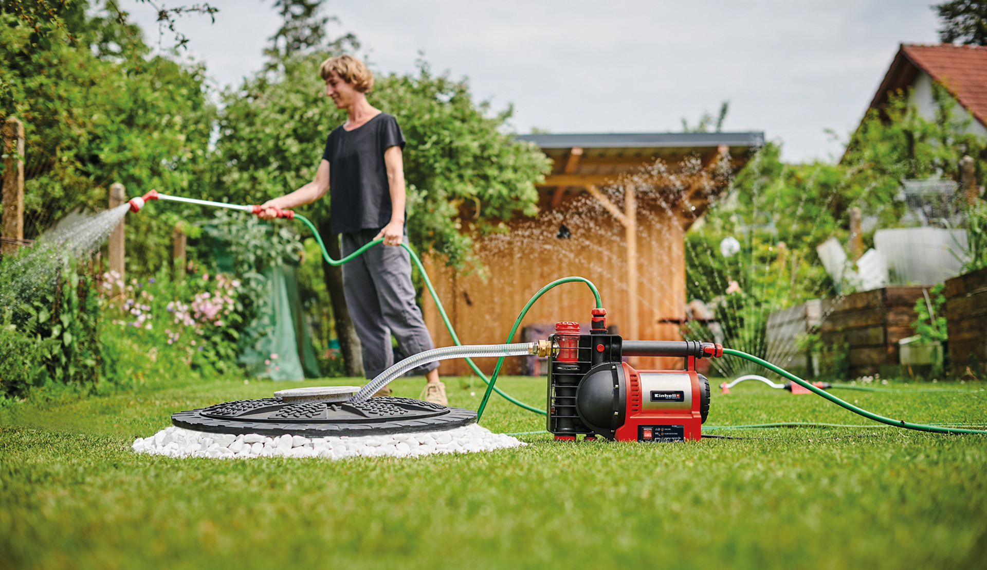 woman waters her flowers with the water from the pump