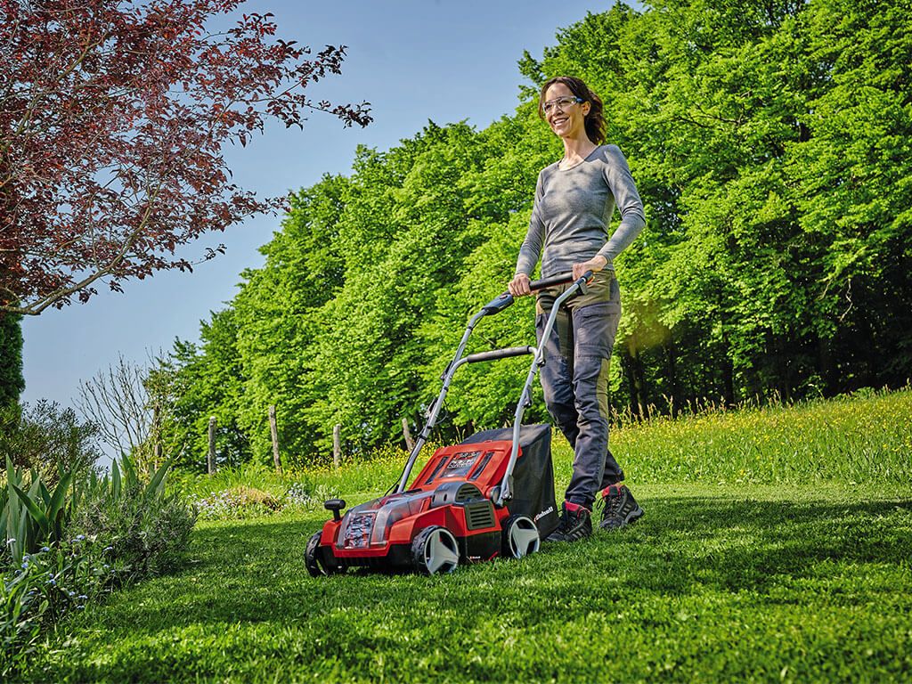 a woman scarifies her lawn