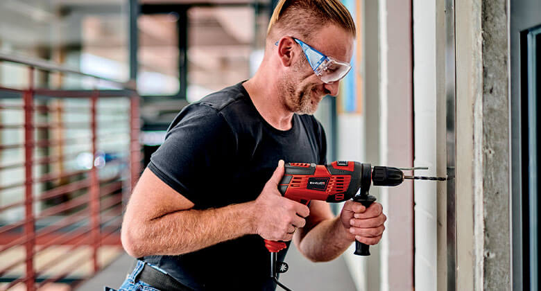 man working with a cabled impact drill