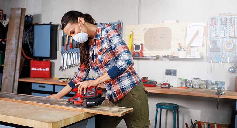 woman using a cordless orbital sander